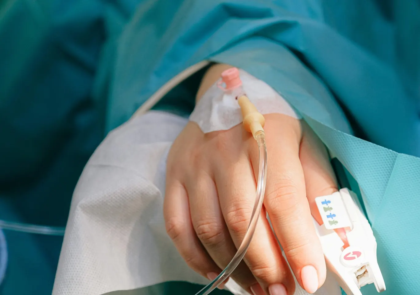 Detoks alkoholowy Inowrocław: dłoń z wenflonem i pulsoksymetrem pod nadzorem